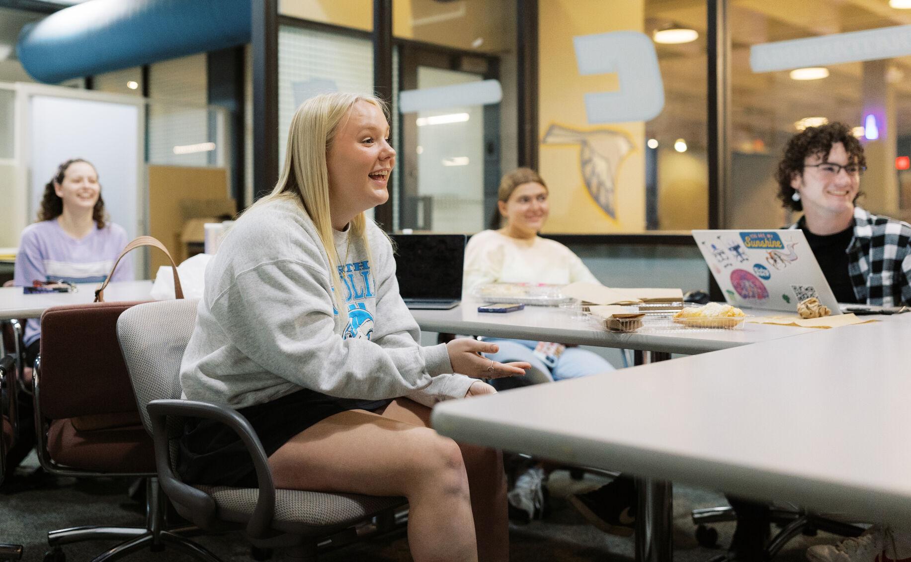 Maddie laughs alongside her editor staff at her last school newspaper meeting.