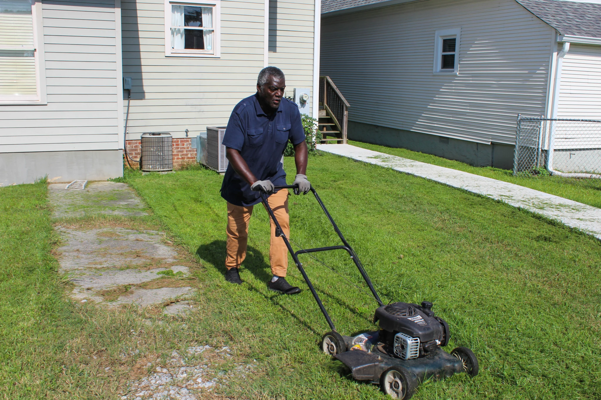 A man mows his neighbor's grass out of the kindness of his heart.