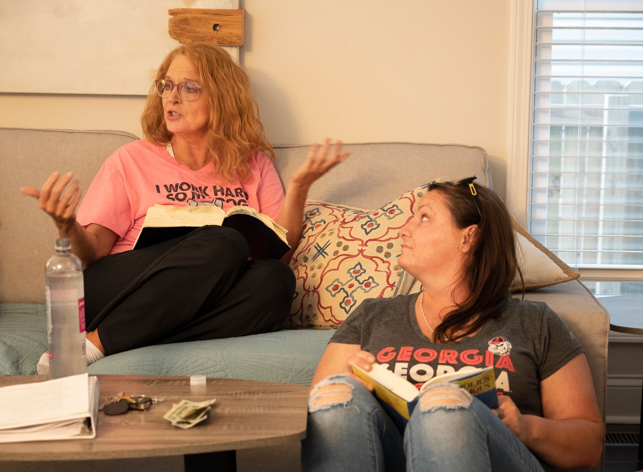 One woman leads a group discussion while the other watches.